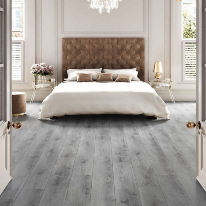 Modern bedroom with Kronotex Superior Standard Plus Summer Oak Grey D3126 7mm Laminate Flooring, white bed, and decorative elements.