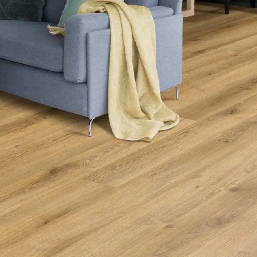 Kronotex Superior Standard Plus Summer Oak Nature D3903 7mm Laminate Flooring with a blue sofa and yellow blanket in the background