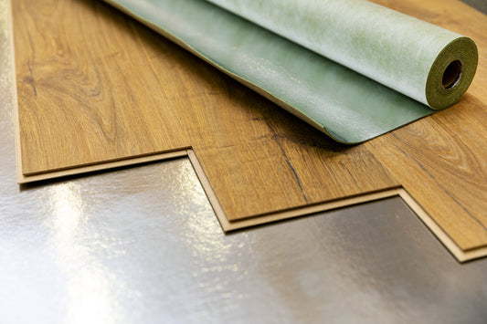 brown laminate flooring being laid over foam and foil underlay