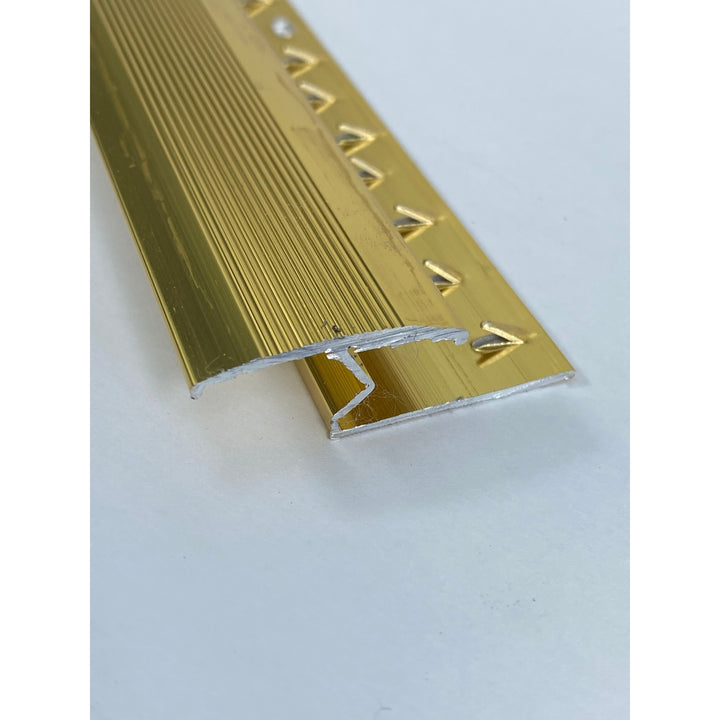 A gold-colored metal doorplate with a serrated edge designed to join two meeting floors.